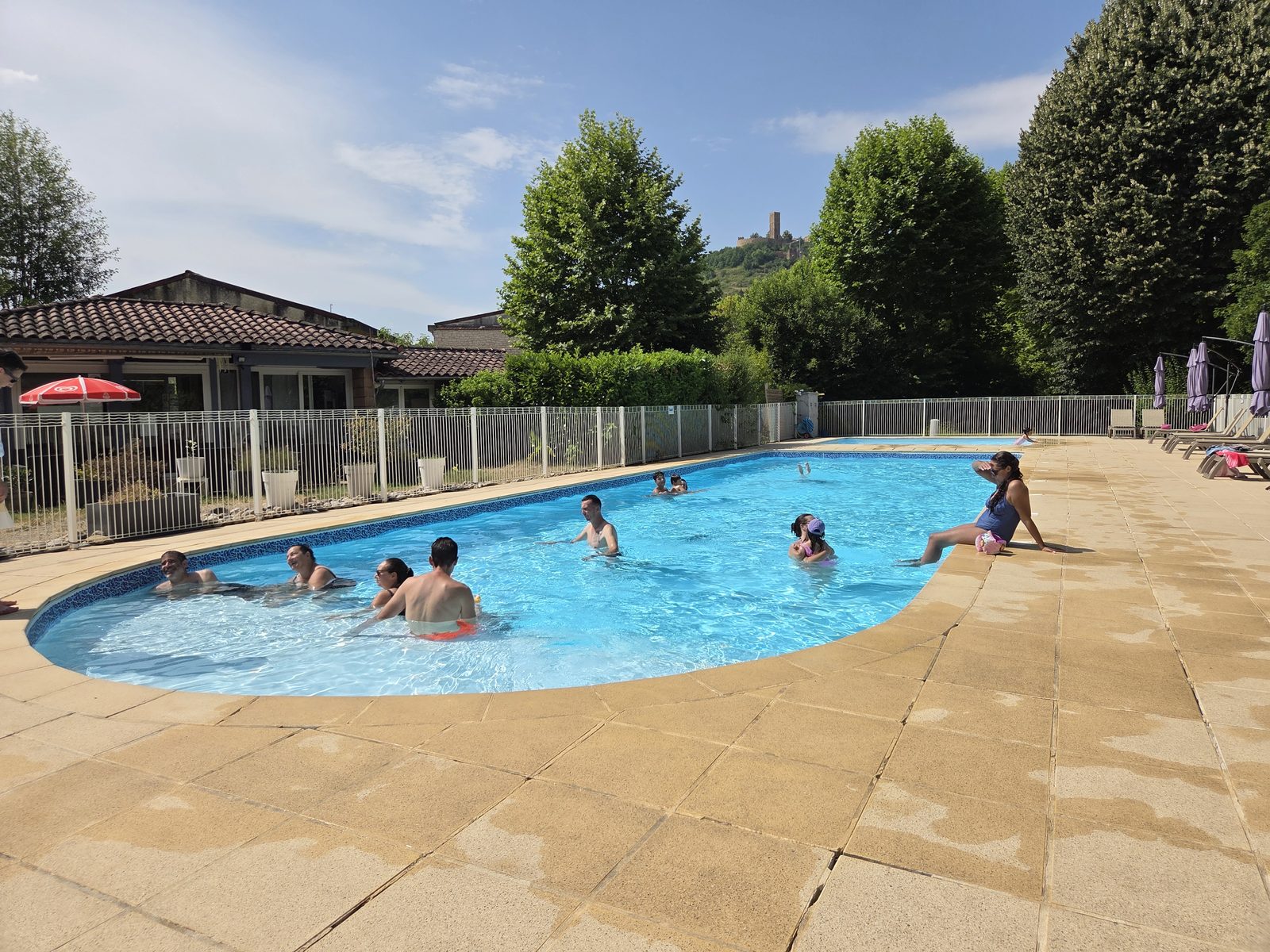 La piscine du Camping Le Soulhol au coucher du soleil, face aux Tours de Saint-Laurent